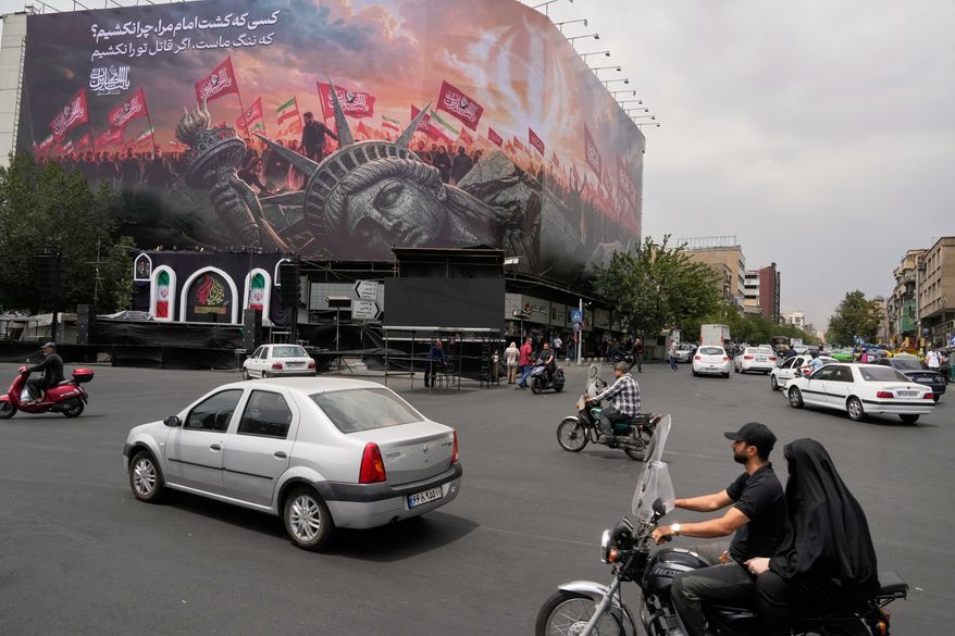 A billboard depicting a fallen Statue of Liberty and crowds carrying Iranian and Shiite flags overlooks Revolution Square in Tehran, Iran, Monday, Aug. 3, 2026. (AP Photo/Vahid Salemi)