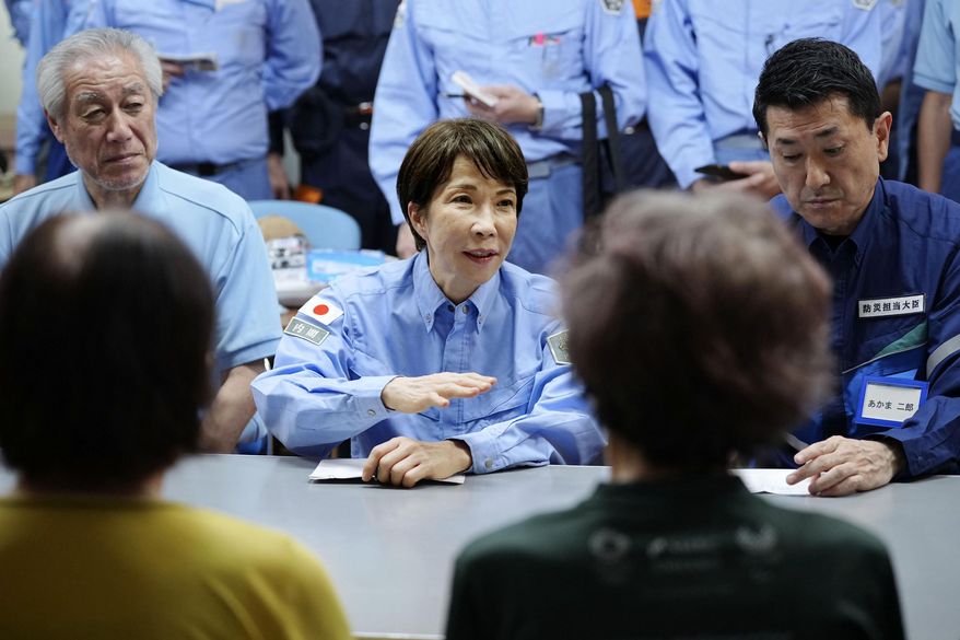 Japan's Prime Minister Sanae Takaichi meets evacuees as she visits an evacuation center in Hikawa, southern Japan, Monday, Aug. 3, 2026. (Japan Pool/Kyodo News via AP)
