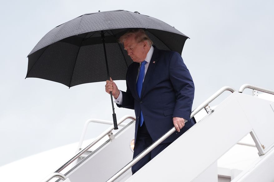 President Donald Trump carries an umbrella as he exits Air Force One at Joint Base Andrews, Md., Sunday, Aug. 2, 2026, on return to Washington. (AP Photo/Jacquelyn Martin)