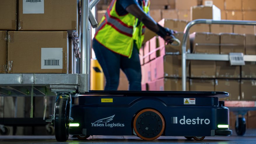 A Destro autonomous robot operating alongside a warehouse associate at a Yusen Logistics facility, demonstrating the companies’ collaboration to improve warehouse operations through intelligent automation.