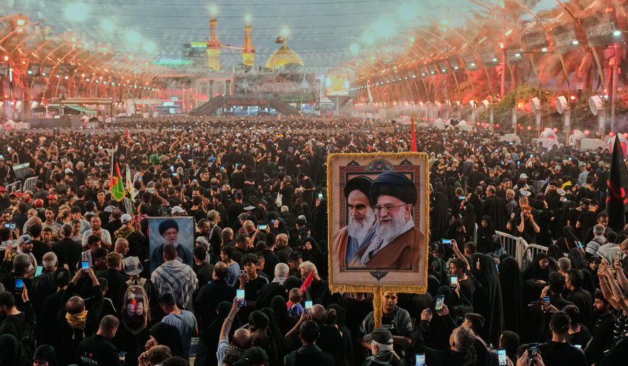 Shiite worshipers carrying a portrait of the late Iranian Supreme Leader Ayatollah Ali Khamenei and the late Iranian Leader Ayatollah Khomeini gather between the holy shrines of Imam Abbas and Imam Hussein during Arbaeen, marking the end of the 40-day mourning period following Ashoura, in Karbala, Iraq, Tuesday, Aug. 4, 2026. (AP Photo/Hadi Mizban)