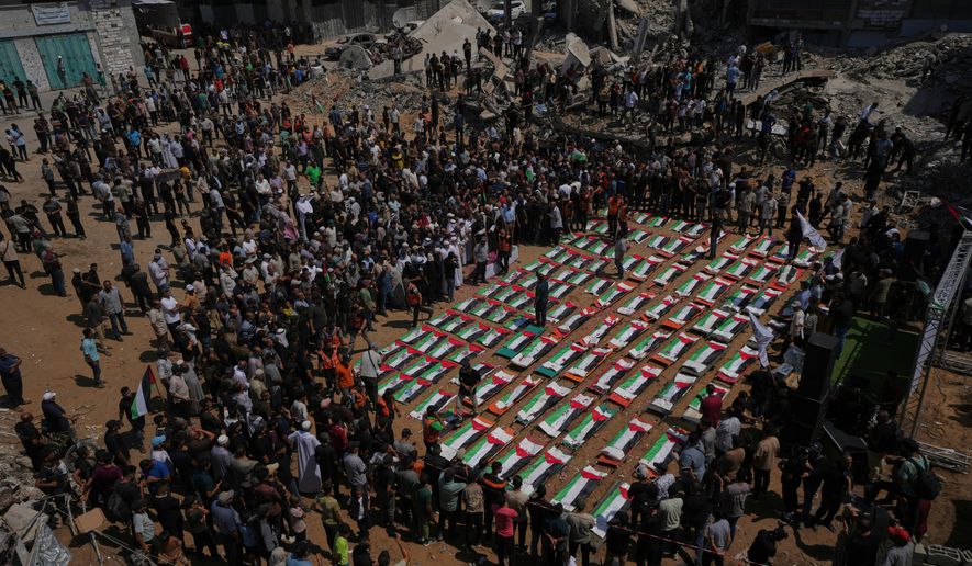 Bodies of members of the Hassayna and Abu Sharia families, killed in an Israeli strike in 2023 and recently recovered from the rubble, are draped in Palestinian flags during their funeral in Gaza City, Tuesday, Aug. 4, 2026. (AP Photo/Jehad Alshrafi)
