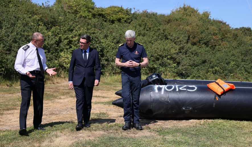 Britain's Prime Minister Andy Burnham, centre, speaks with John Craig, Interim Chief Coastguard, and Duncan Capps, Border Security Commander (DG BSC), left, near a recovered small boat, which was used by migrants crossing the English Channel, during a visit to HM Coastguard Maritime Rescue Coordination Centre, in Dover, Britain, Aug. 2, 2026. (Jack Taylor/Pool Photo via AP)