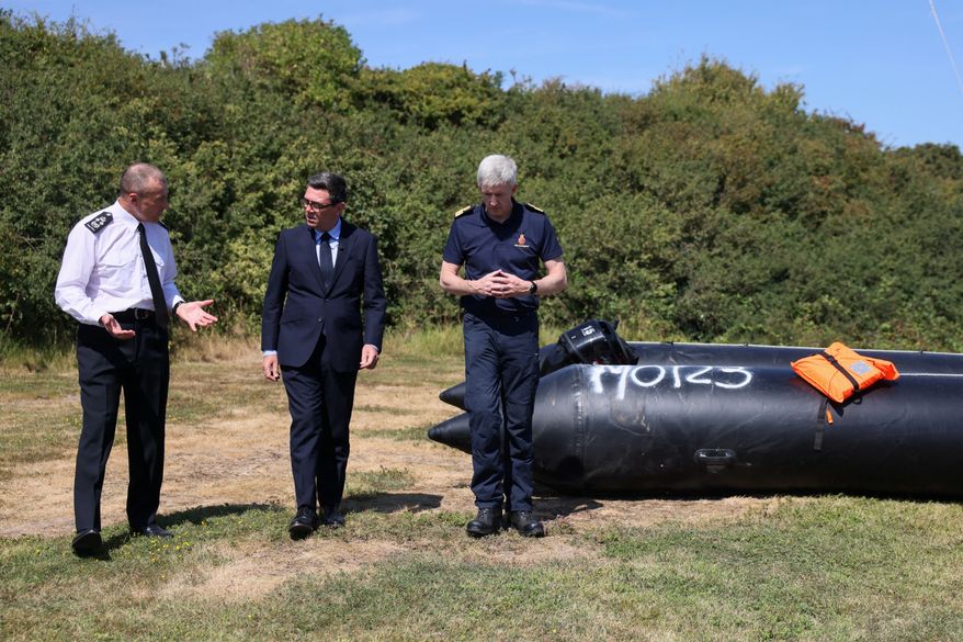 Britain's Prime Minister Andy Burnham, centre, speaks with John Craig, Interim Chief Coastguard, and Duncan Capps, Border Security Commander (DG BSC), left, near a recovered small boat, which was used by migrants crossing the English Channel, during a visit to HM Coastguard Maritime Rescue Coordination Centre, in Dover, Britain, Aug. 2, 2026. (Jack Taylor/Pool Photo via AP)