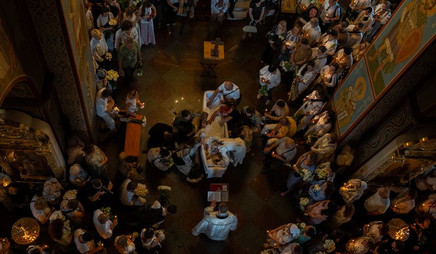 Relatives and friends mourn near the coffin of Vitalina Yarovenko, 20, during the funeral ceremony in Kyiv, Ukraine, Tuesday, Aug. 4, 2026. (AP Photo/Alex Babenko)