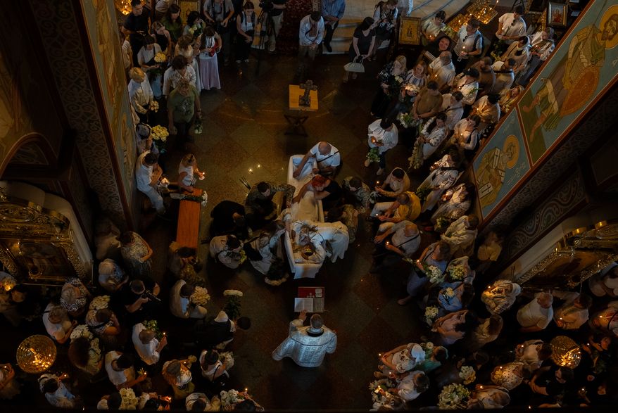 Relatives and friends mourn near the coffin of Vitalina Yarovenko, 20, during the funeral ceremony in Kyiv, Ukraine, Tuesday, Aug. 4, 2026. (AP Photo/Alex Babenko)