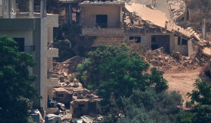Israeli military vehicles, left, are seen stationed among homes in the village of Zawtar al-Sharqiyah, occupied by Israeli forces, is seen from the southern village of Zawtar al-Gharbieh, Lebanon, Wednesday, Aug. 5, 2026. (AP Photo/Mohammed Zaatari)
