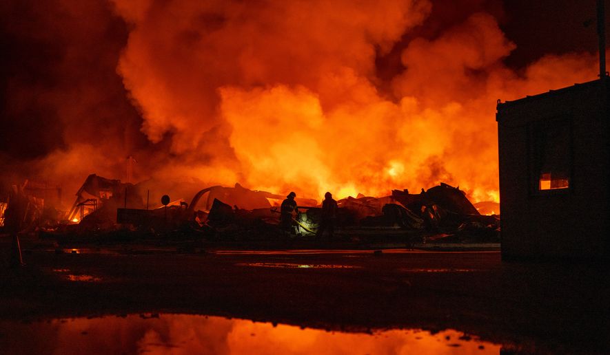Firefighters put out a fire after Russian missiles hit a warehouse in Kyiv, Ukraine, Wednesday, Aug. 5, 2026. (AP Photo/Dan Bashakov)
