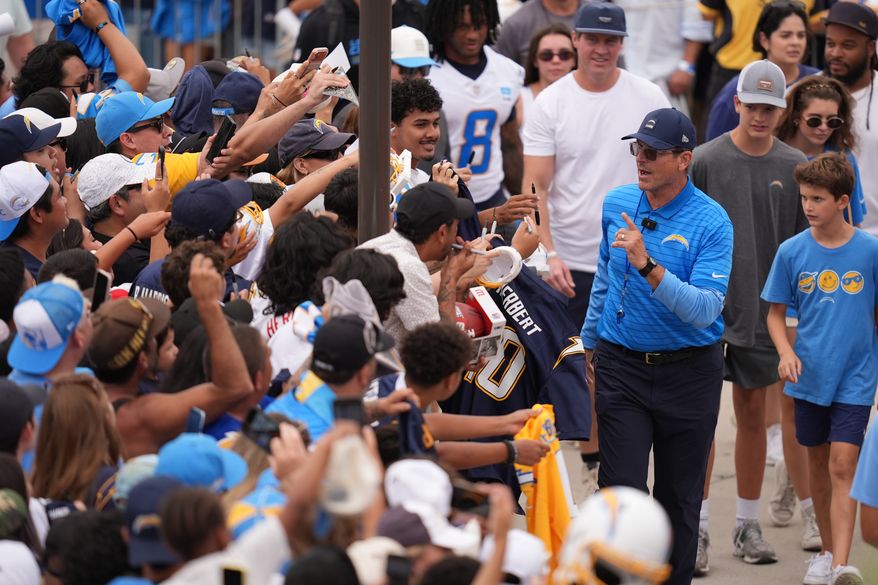 Los Angeles Chargers head coach Jim Harbaugh greets fans during an NFL football training camp Wednesday, Aug. 5, 2026, in San Diego. (AP Photo/Gregory Bull)