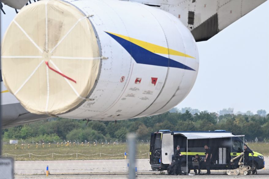 Police forensic technicians prepare to deploy an explosive-disposal robot near a Ukrainian aircraft at Leipzig/Halle Airport, in Schkeuditz, Germany, Wednesday Aug. 5, 2026, where flight operations were suspended overnight after a drone sighting was reported and another object was found near a runway. (Hendrik Schmidt/dpa via AP)