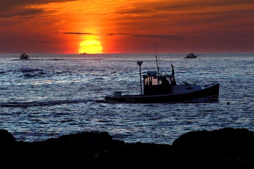 FILE - Lobster fishermen work at sunrise, Sept. 8, 2022, off Kennebunkport, Maine. (AP Photo/Robert F. Bukaty, File)