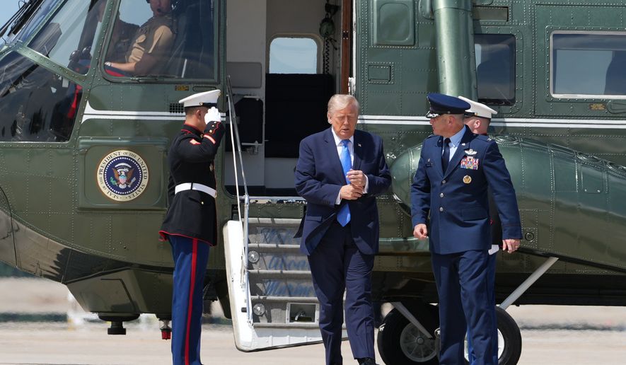 President Donald Trump walks from Marine One with Air Force Col. Christopher M. Robinson, commander of the 89th Airlift Wing, to board Air Force One, Tuesday, Aug. 4, 2026, at Joint Base Andrews, Md. (AP Photo/Mark Schiefelbein)
