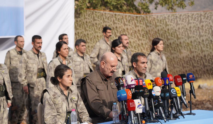 Kurdistan Workers' Party (PKK) fighters, who reportedly withdrew from Turkey with their weapons, stand to attention during a ceremony in the Qandil area of northern, Iraq, Sunday, Oct 26, 2025. (AP Photo/Rashid Yahya, File)