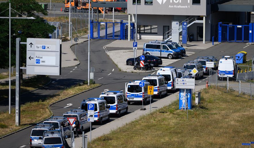 Police vehicles are parked at Leipzig/Halle Airport, where investigations are underway following the drone incident that occurred early Wednesday morning, in Schkeuditz, Germany, Thursday Aug. 6, 2026. (Hendrik Schmidt/dpa via AP)