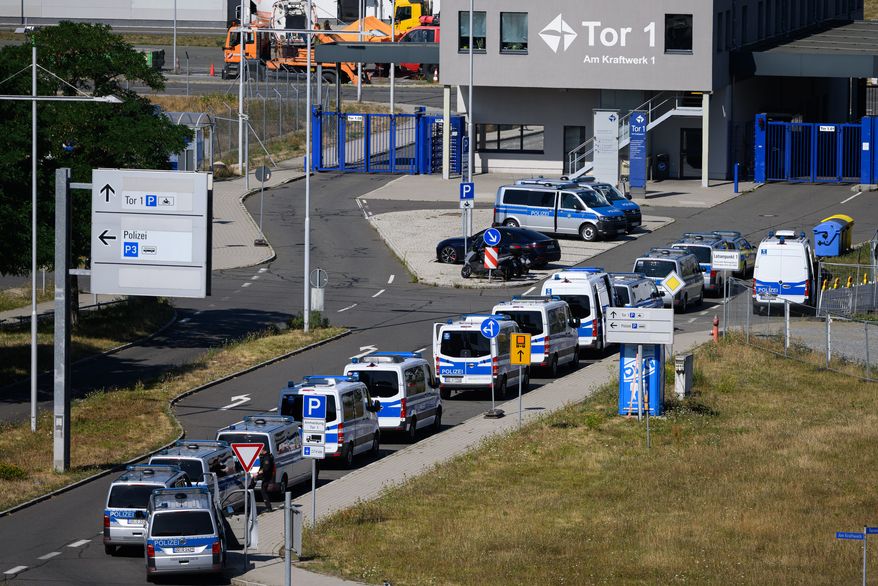 Police vehicles are parked at Leipzig/Halle Airport, where investigations are underway following the drone incident that occurred early Wednesday morning, in Schkeuditz, Germany, Thursday Aug. 6, 2026. (Hendrik Schmidt/dpa via AP)