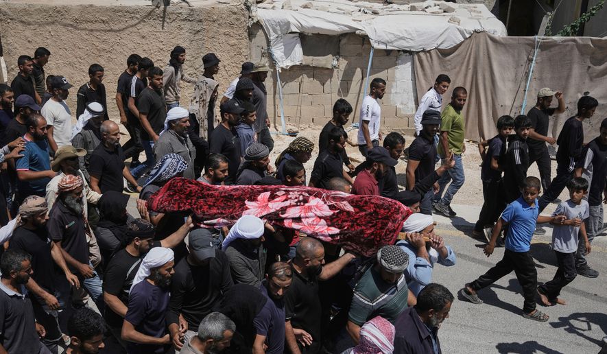 FILE -Mourners carry the body of Palestinian activist Awdah Al Hathaleen, who was killed by Israeli settler according to Palestinian health officials, during his funeral in the West Bank Bedouin village of Umm al-Khair, Aug. 7, 2025. (AP Photo/Mahmoud Illean, File)