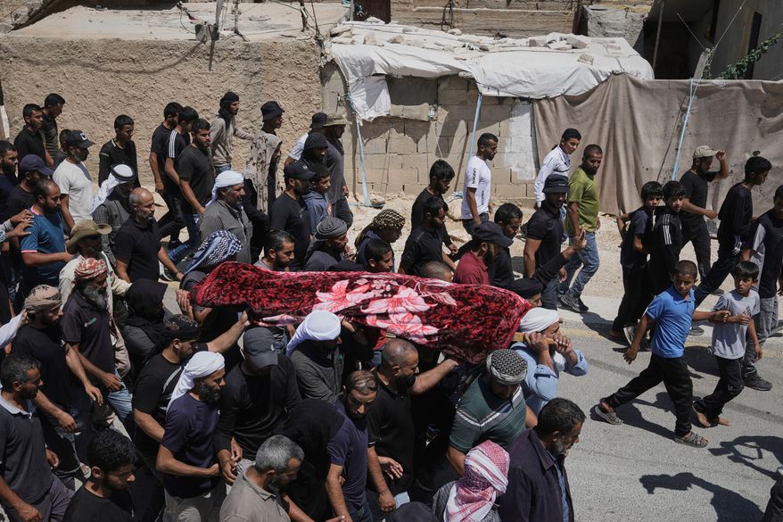 FILE -Mourners carry the body of Palestinian activist Awdah Al Hathaleen, who was killed by Israeli settler according to Palestinian health officials, during his funeral in the West Bank Bedouin village of Umm al-Khair, Aug. 7, 2025. (AP Photo/Mahmoud Illean, File)