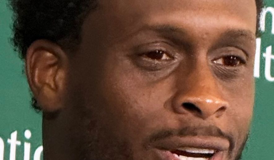 New York Jets quarterback Geno Smith, wearing red contact lenses, speaks to reporters after practice at the team’s training facility in Florham Park, N.J., on Thursday, Aug. 6, 2026. (AP Photo/Dennis Waszak Jr.)