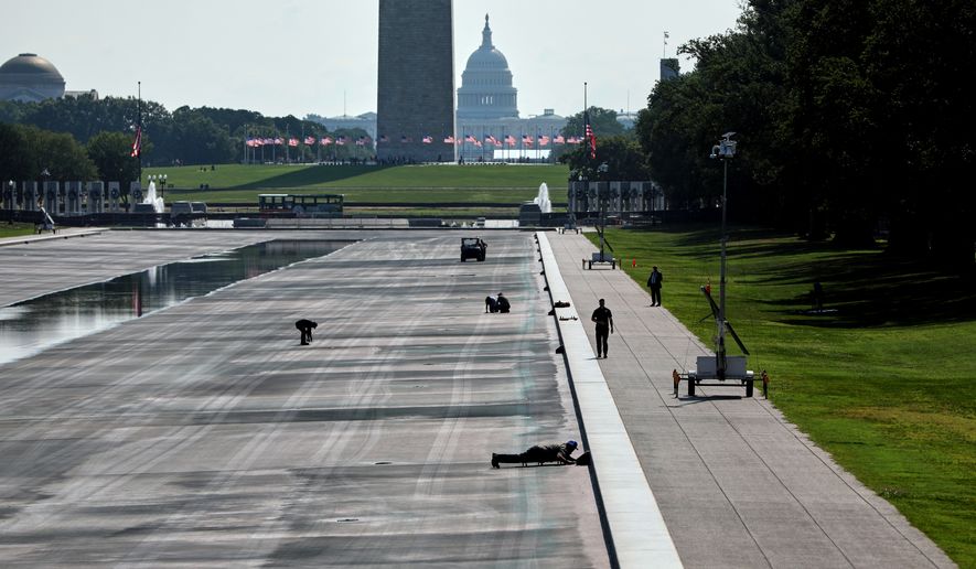 National Park Service workers work at the Lincoln Memorial Reflecting Pool, Wednesday, July 29, 2026, in Washington. (AP Photo/Rahmat Gul)