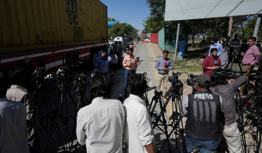 FILE -Members of media report from a road leading to police headquarters, in Islamabad, Pakistan, Wednesday, May 10, 2023. (AP Photo/Anjum Naveed, File)