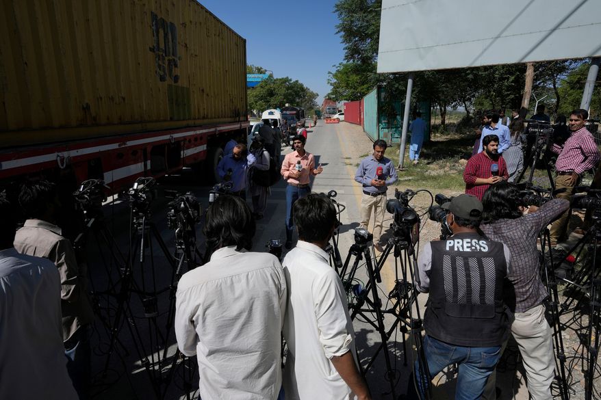 FILE -Members of media report from a road leading to police headquarters, in Islamabad, Pakistan, Wednesday, May 10, 2023. (AP Photo/Anjum Naveed, File)
