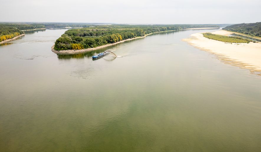 A dredger ship operates on the Danube River after a controlled demolition of submerged rocks to improve water flow to the Cernavoda Nuclear Power Plant amid exceptionally low water levels of the Danube River, in Izvoarele, Romania, Monday, Aug. 3 2026. (AP Photo/ Vadim Ghirda)