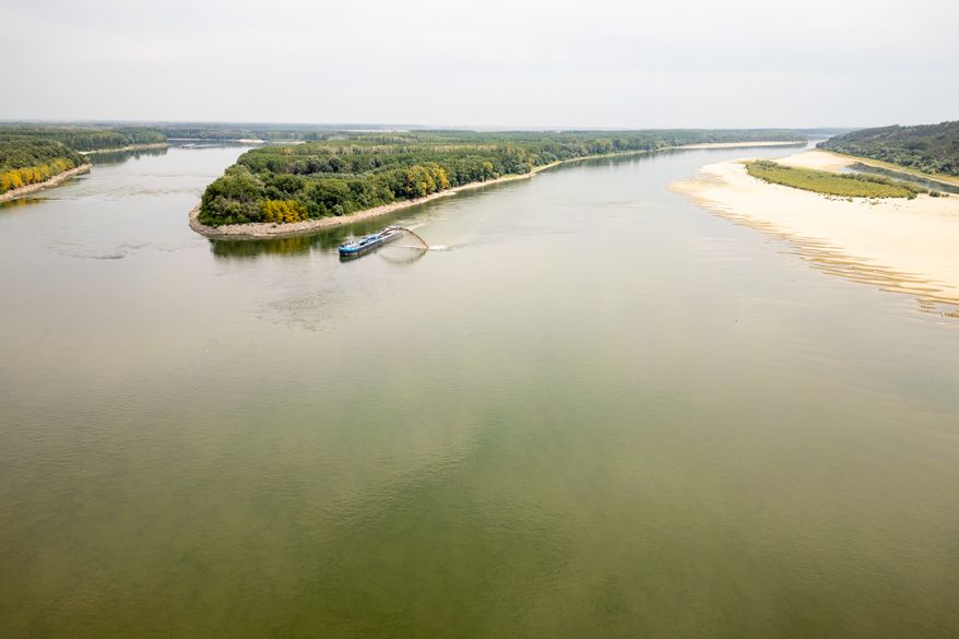 A dredger ship operates on the Danube River after a controlled demolition of submerged rocks to improve water flow to the Cernavoda Nuclear Power Plant amid exceptionally low water levels of the Danube River, in Izvoarele, Romania, Monday, Aug. 3 2026. (AP Photo/ Vadim Ghirda)