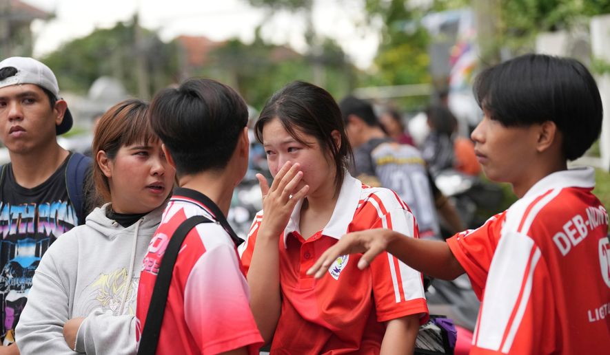 A schoolgirl cries outside her school where deaths and injuries were reported after a shooting in Thailand's Nonthaburi province, Friday, Aug. 7, 2026. (AP Photo/Sakchai Lalit)