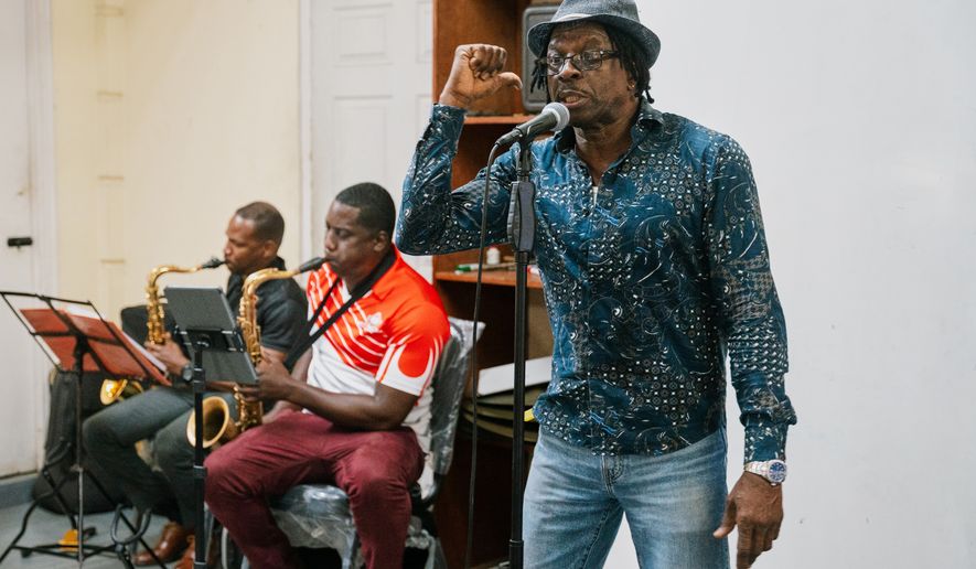 Father Gerard Paul, who can no longer officiate masses, funerals, weddings or baptisms after repeatedly criticizing the church and clergy, rehearses with the Royal Grenada Police Force Band in St. George, Grenada, Thursday, Aug. 6, 2026. (AP Photo/Floyd Robinson)