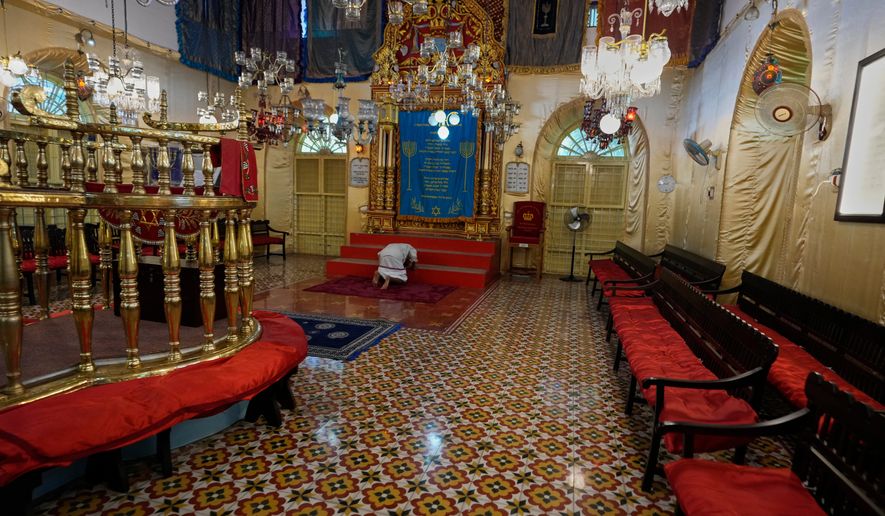 An Indian man prostrates himself in a traditional Hindu gesture of obeisance to the Torah ark during his visit to the 12th-century Kadavumbagam Synagogue in Ernakulam, mainland district of Kochi, India, Thursday, May 21, 2026. (AP Photo/Aijaz Rahi)