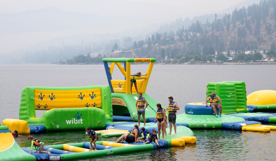 People play at the Peachland Water Park in Peachland, British Columbia, Canada, on Saturday, Aug. 8, 2026. (Gary Nylander/The Canadian Press via AP)