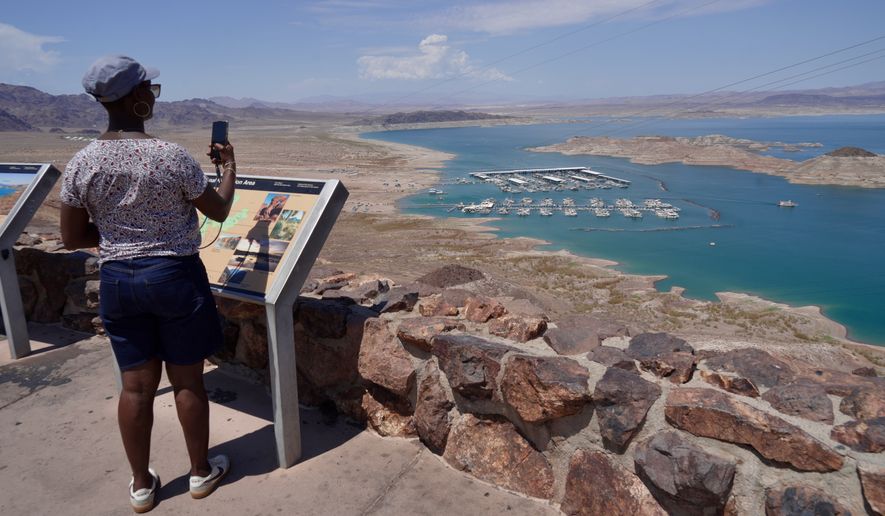 A tourist takes a photo of Lake Mead near Boulder City, Nev., on Friday, Aug. 7, 2026. (AP Photo/Ty ONeil)