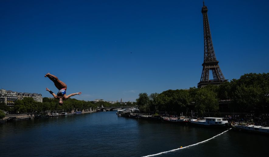 France's Madeleine Bayon competes during round 1 of the Women's 20m Platform as the Eiffel Tower is seen in the background at the European Aquatics Championships in Paris, Friday, Aug. 7, 2026. (AP Photo/Aurelien Morissard)