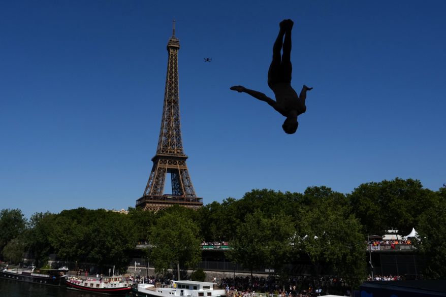 Italy's Andrea Barnaba competes in front of the Eiffel Tower during round 1 of the men's 20m Platform high diving at the European Aquatics Championships in Paris, Friday, Aug. 7, 2026. (AP Photo/Aurelien Morissard)