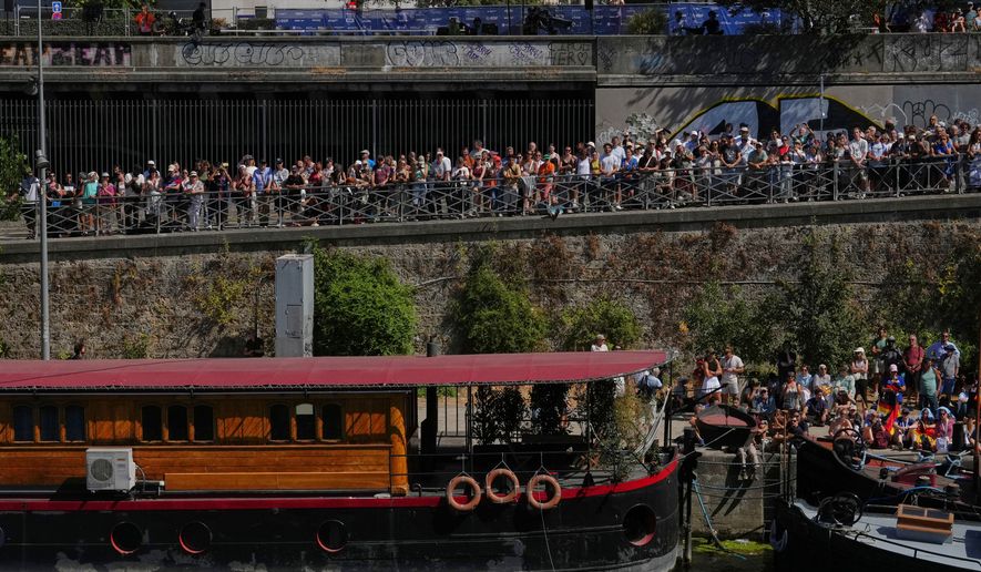 Spectators line the banks of the Seine river to watch the 20m Platform high diving at the European Aquatics Championships in Paris, Friday, Aug. 7, 2026. (AP Photo/Aurelien Morissard)