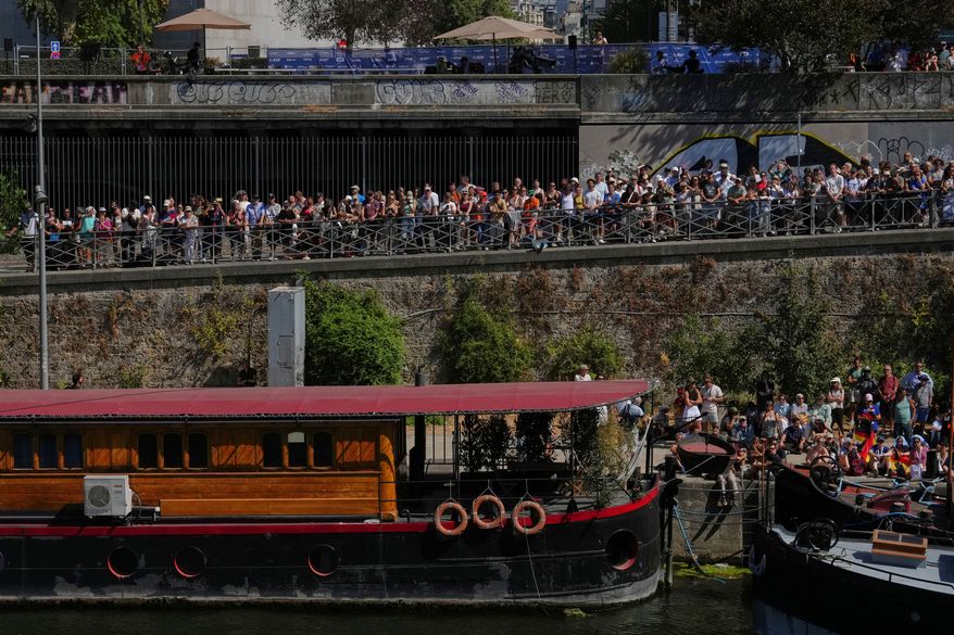 Spectators line the banks of the Seine river to watch the 20m Platform high diving at the European Aquatics Championships in Paris, Friday, Aug. 7, 2026. (AP Photo/Aurelien Morissard)