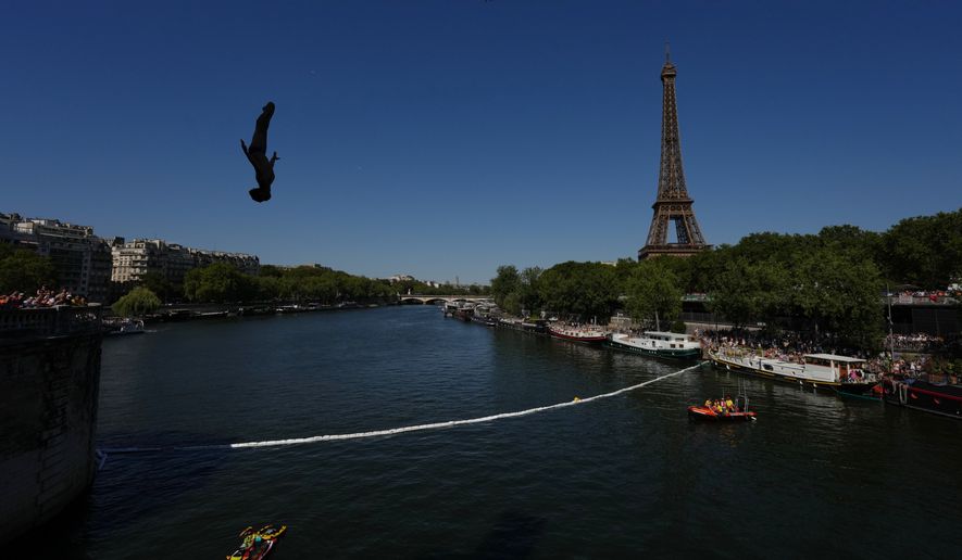 Spain's Carlos Javier Gimeno Martinez competes in front of the Eiffel Tower during round 1 of the men's 20m Platform high diving at the European Aquatics Championships in Paris, Friday, Aug. 7, 2026. (AP Photo/Aurelien Morissard)