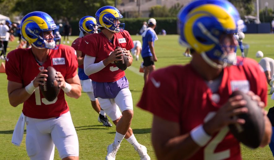 Los Angeles Rams quarterbacks, from left, Ty Simpson, Stetson Bennett, Matthew Stafford and Matthew Caldwell get set to pass during the NFL football team's training camp, Thursday, Aug. 6, 2026, in Los Angeles. (AP Photo/Mark J. Terrill)