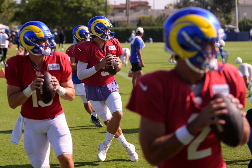 Los Angeles Rams quarterbacks, from left, Ty Simpson, Stetson Bennett, Matthew Stafford and Matthew Caldwell get set to pass during the NFL football team's training camp, Thursday, Aug. 6, 2026, in Los Angeles. (AP Photo/Mark J. Terrill)