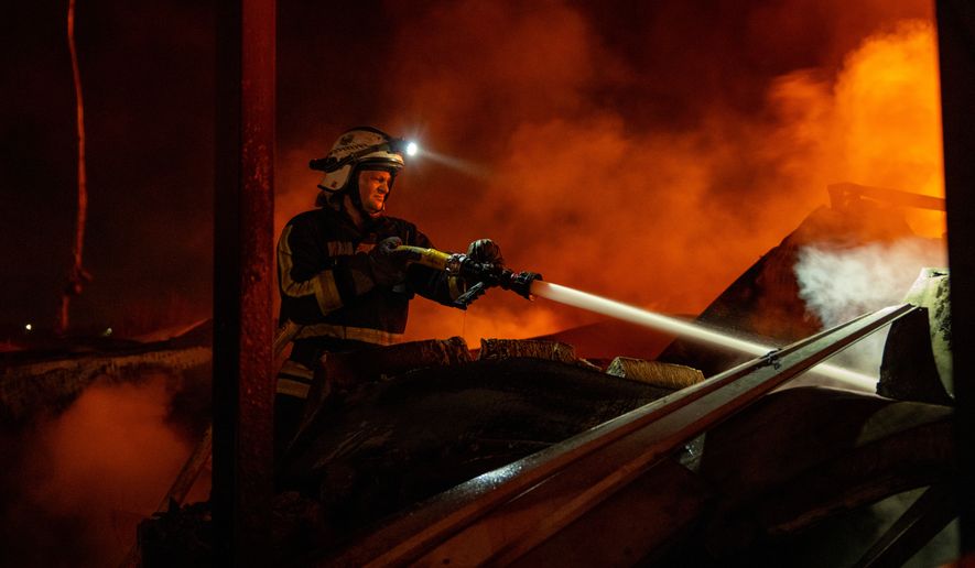 Firefighters put out a fire after Russian missiles hit a warehouse in Kyiv, Ukraine, Wednesday, Aug. 5, 2026. (AP Photo/Dan Bashakov)