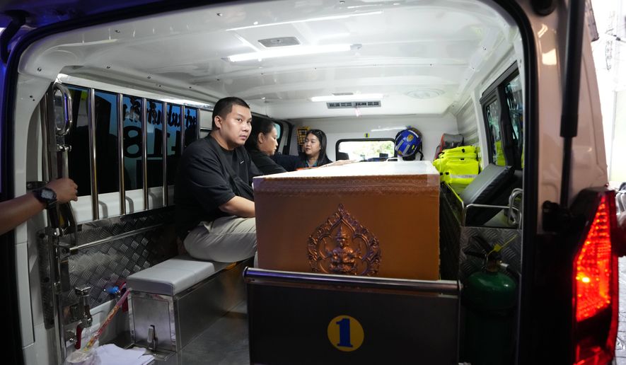 A relative sits near a coffin containing the body of a victim of Friday's shooting at the Debsirin Nonthaburi School, inside an ambulance at a police hospital in Bangkok,Thailand, Saturday, Aug. 8, 2026. (AP Photo/Sakchai Lalit)
