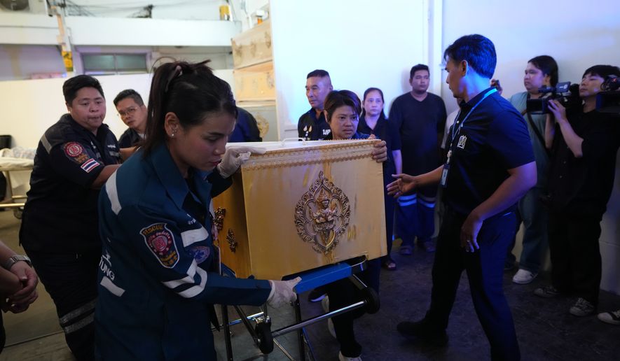 A coffin containing the body of a victim of Friday's shooting at the Debsirin Nonthaburi School, is brought in a stretcher at a police hospital in Bangkok,Thailand, Saturday, Aug. 8, 2026. (AP Photo/Sakchai Lalit)