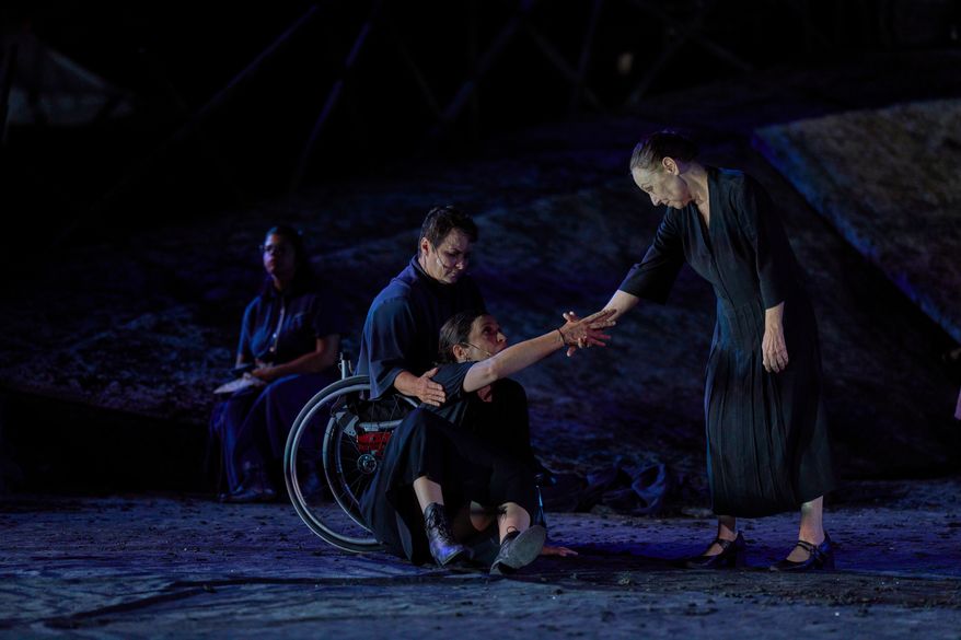 From left to right, Eirini Kourouvani, a wheelchair dancer, Evi Saoulidou and Lydia Fotopoulou perform during a dress rehearsal of Euripides' tragedy The Trojan Women, staged by the National Theatre of Greece, at the Ancient Theater of Epidaurus, Greece, on Thursday, July 30, 2026. (AP Photo/Petros Giannakouris)