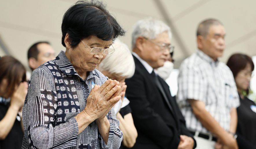 People observe a minute of silence during a ceremony to mark the 81st anniversary of the U.S. atomic bombing at the Peace Park in Nagasaki, southern Japan Sunday, Aug. 9, 2026. (Taichi Nagahisa/Kyodo News via AP)