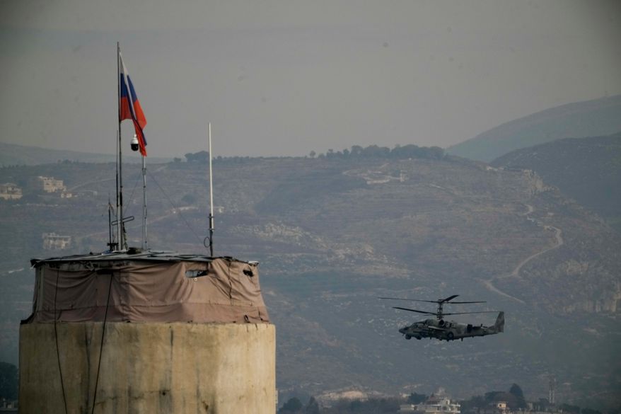 FILE - A Russian helicopter flies over the Hmeimim Air Base located southeast of the city of Latakia in the town of Hmeimim, Syria, Dec. 16, 2024. (AP Photo/Leo Correa, File)