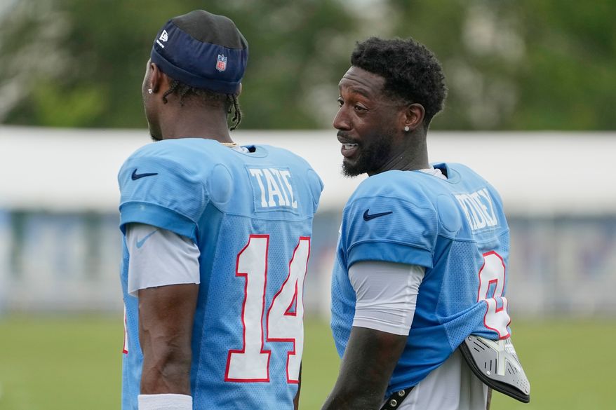 Tennessee Titans wide receivers Calvin Ridley, right, Carnell Tate (14) talks with each other after practice during the NFL football team's training camp Tuesday, Aug. 4, 2026, in Nashville, Tenn. (AP Photo/George Walker IV)