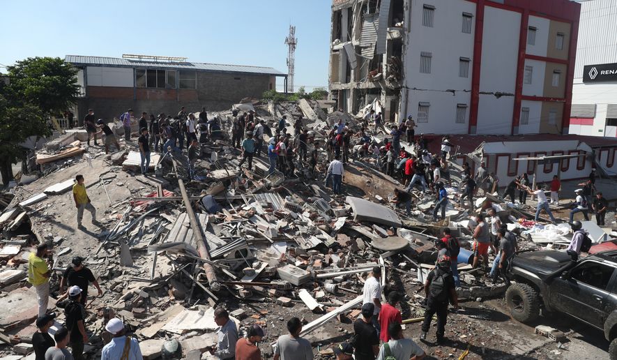 Residents and rescue workers search through the rubble of a collapsed building after an earthquake struck Cali, Colombia, Monday, Aug. 10, 2026. (AP Photo/Santiago Saldarriaga)