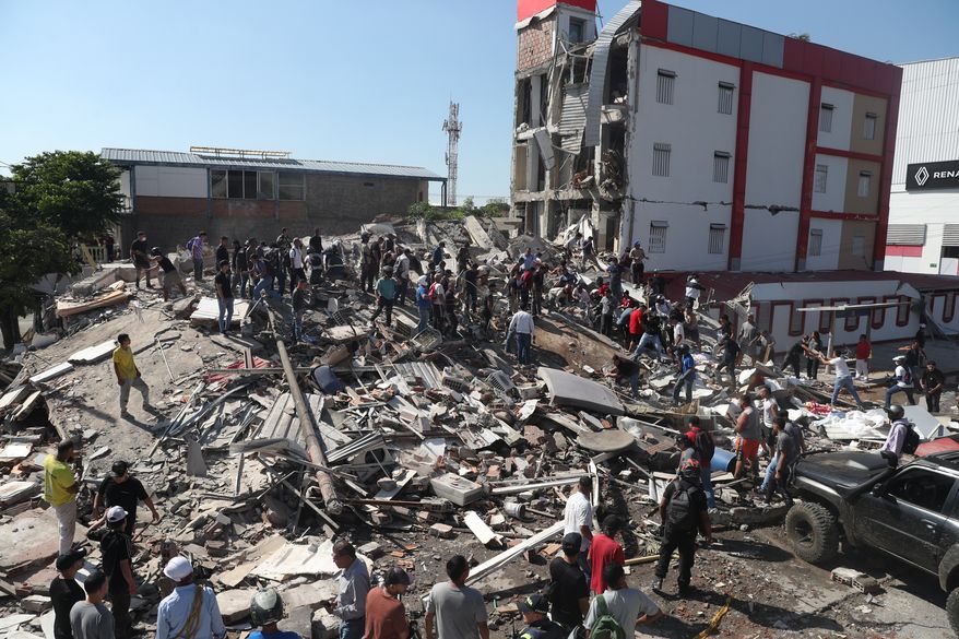 Residents and rescue workers search through the rubble of a collapsed building after an earthquake struck Cali, Colombia, Monday, Aug. 10, 2026. (AP Photo/Santiago Saldarriaga)