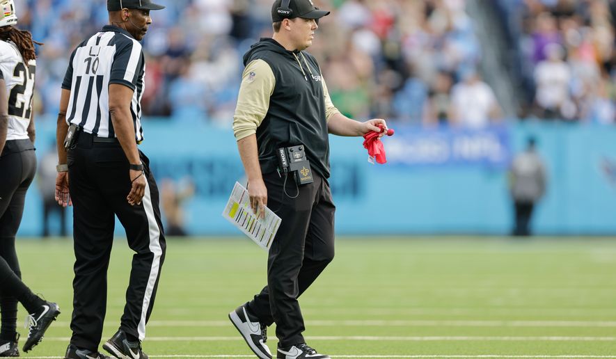 FILE - New Orleans Saints head coach Kellen Moore prepares to drop the red challenge flag during the second half of an NFL football game against the Tennessee Titans, Dec. 28, 2025, in Nashville, Tenn. (AP Photo/Stew Milne, File)