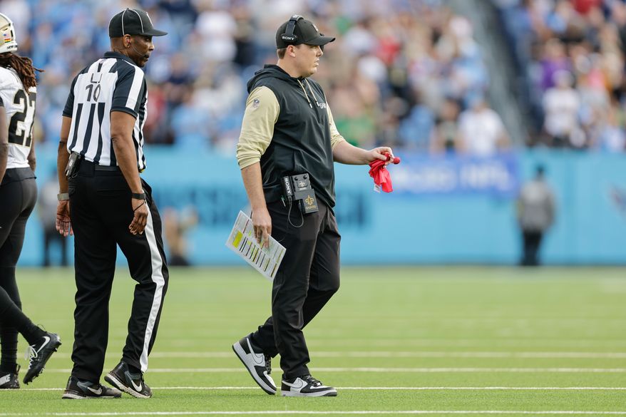 FILE - New Orleans Saints head coach Kellen Moore prepares to drop the red challenge flag during the second half of an NFL football game against the Tennessee Titans, Dec. 28, 2025, in Nashville, Tenn. (AP Photo/Stew Milne, File)